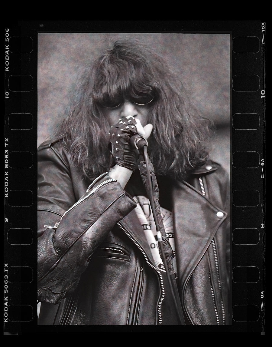 Joey Ramone of The Ramones singing, in black and white with the film rebate showing, Lollapalooza 1996