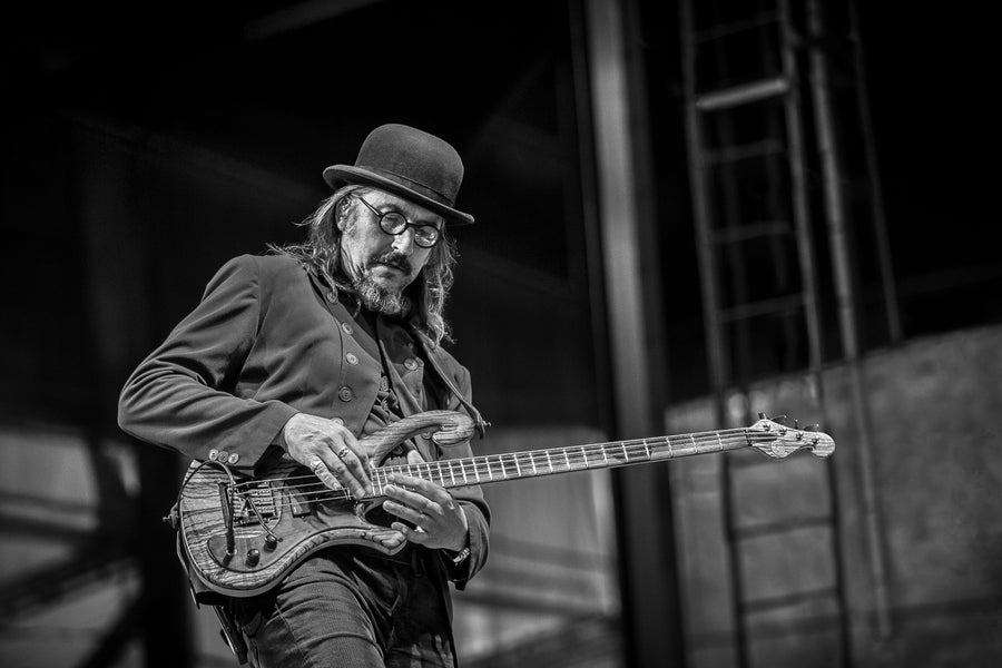 Les Claypool in a bowler hat playing bass in black and white, The Peach Music Festival, Scranton