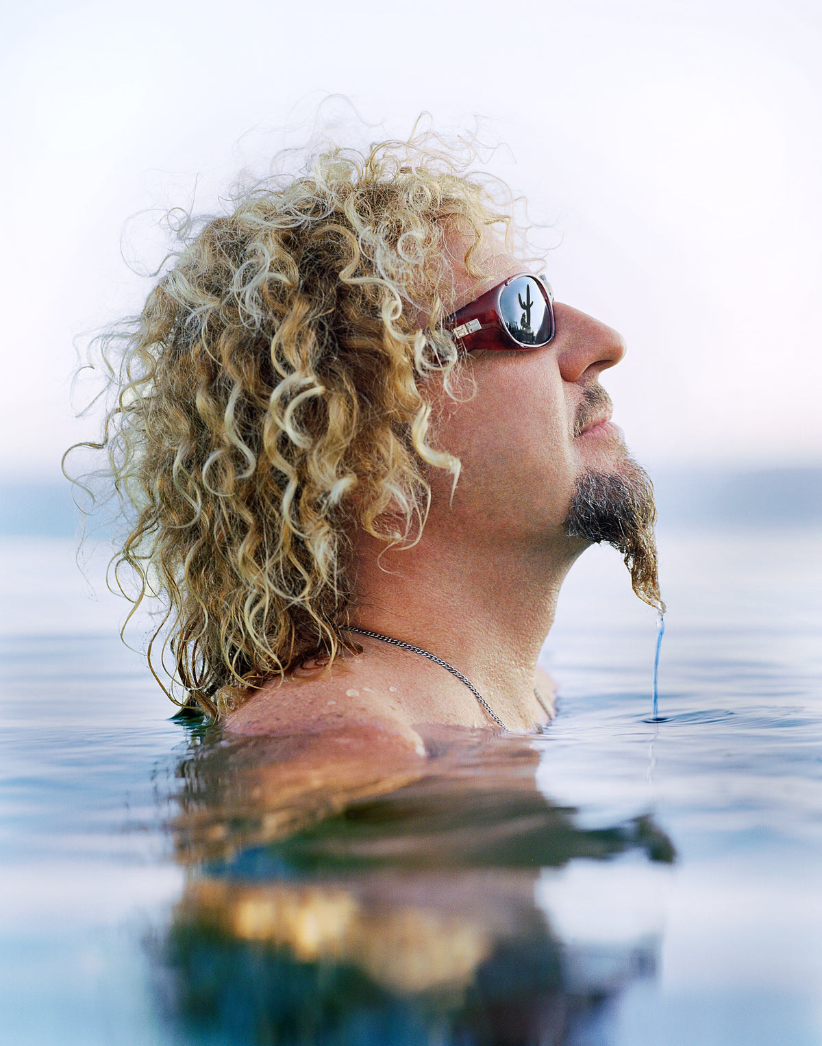 Sammy Hagar shoulder-deep in mirror-still water, head tilted back in sunglasses, Cabo San Lucas 2004. Museum-quality archival print, signed and certified.